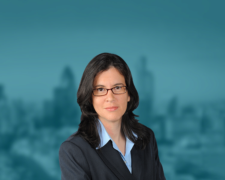 Clare A. Casas stands with the Coral Springs skyline in the background, which has a blue filter applied.